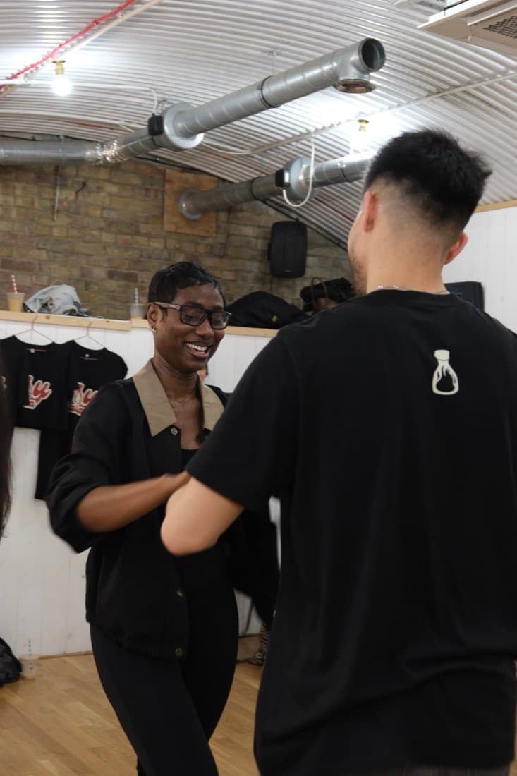 A student laughing while dancing with a partner
