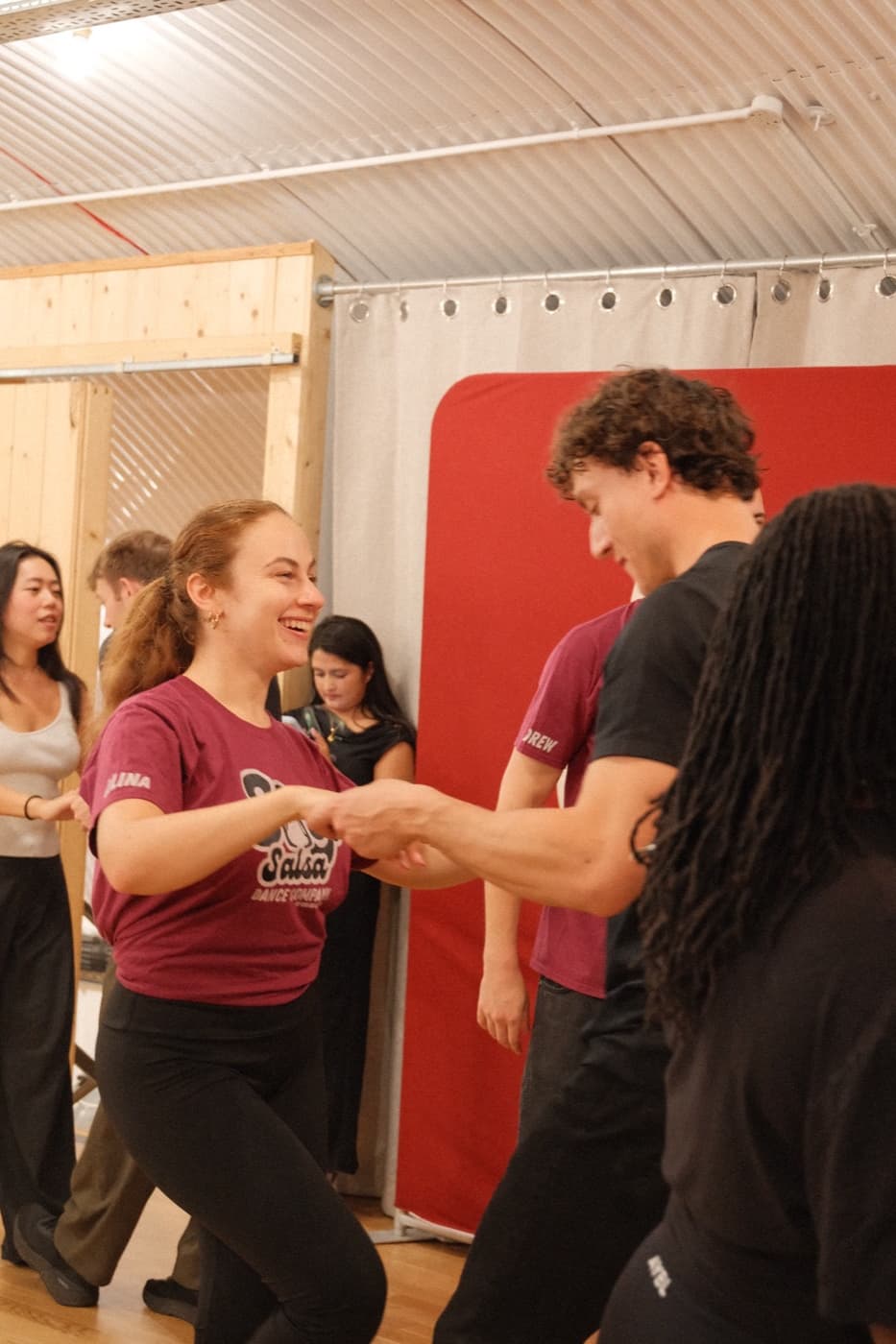 A Soy Salsa student laughing with her partner mid-dance